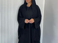 A Stylish, Loose-fitting Long Cardigan With Wavy Trim, Paired With Two Headscarves.