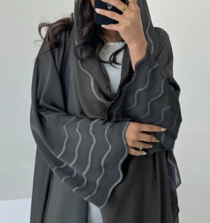 A Stylish, Loose-fitting Long Cardigan With Wavy Trim, Paired With Two Headscarves.