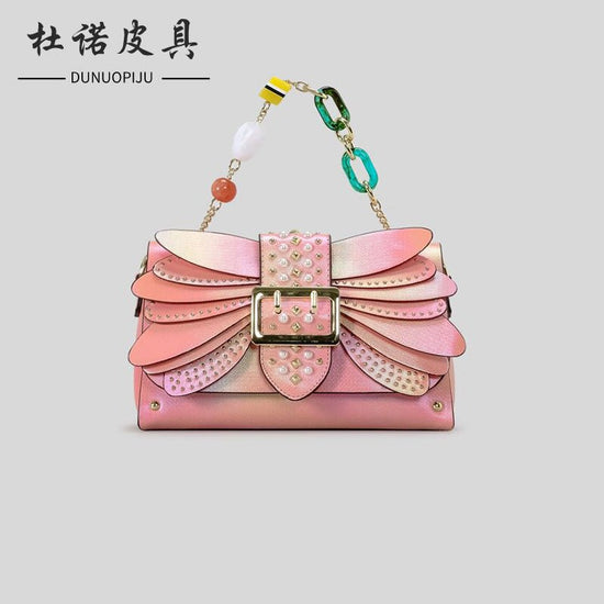 Contrast Color Heavy Industry Manual Rivet Butterfly Wings Handbag $99.00 Dana Fashion Color: Pink Women's Bags Product information: Applicable scenario: leisure travel Color: pink, purple Outer bag type: open pocket Hardness: medium hard Material: PU Sui